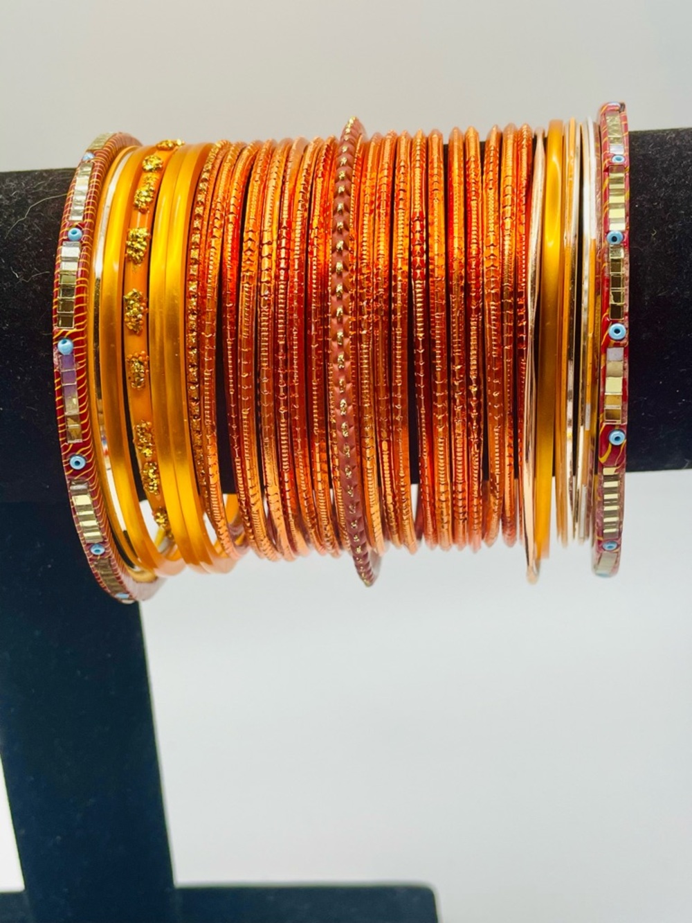 Orange Acrylic & Metal Stacked Bangle Set. 32 bracelets. Size 7 1/2 to 8 inches.